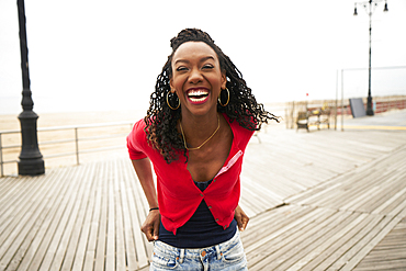 Black woman laughing on boardwalk