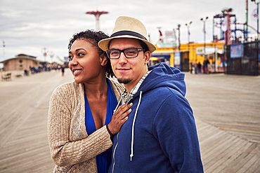 Couple standing on boardwalk at amusement park