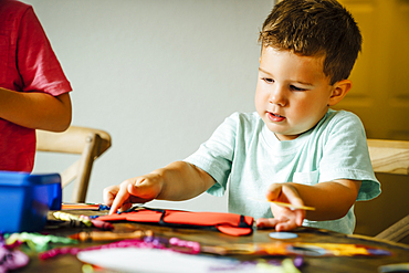 Caucasian boy making mask on table