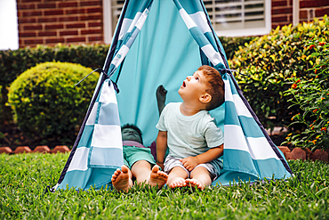 Caucasian brothers in backyard teepee