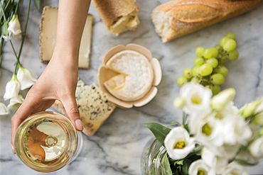 Hispanic woman drinking wine with cheese