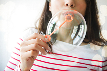 Hispanic woman blowing bubbles