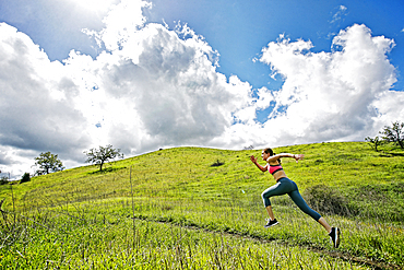 Caucasian woman running on hill