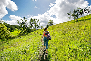 Caucasian woman walking on hill carrying bag