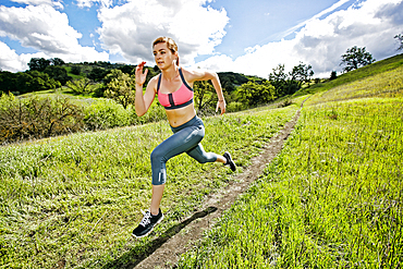 Caucasian woman running on hill