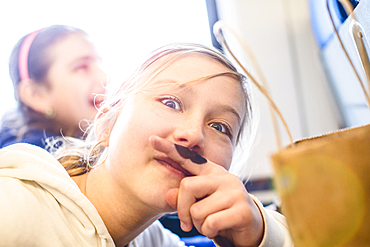 Caucasian girl with mustache on finger