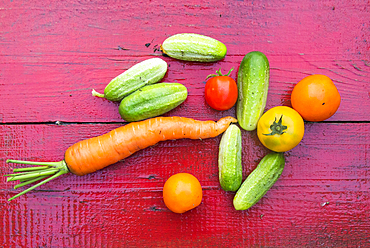 Close up of fresh vegetables on red wooden table