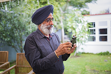 Indian man texting on cell phone