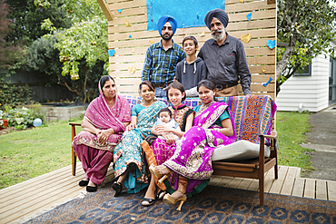 Multi-generation family posing on patio bench