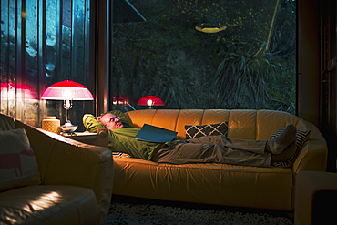 Caucasian man relaxing on sofa with book