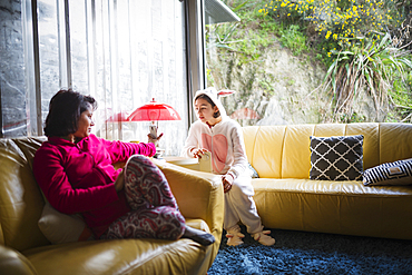 Mother showing cell phone to daughter wearing rabbit costume