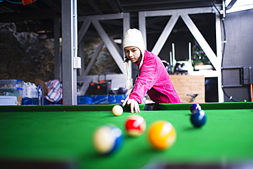 Mixed Race girl playing at pool table