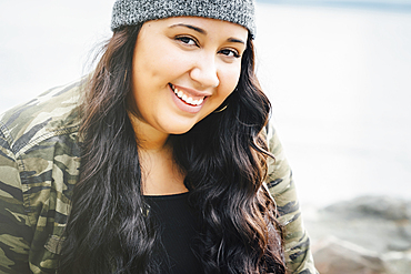 Smiling Mixed Race woman at ocean