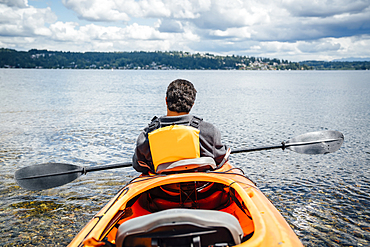 Mixed Rave man sitting in kayak holding paddle