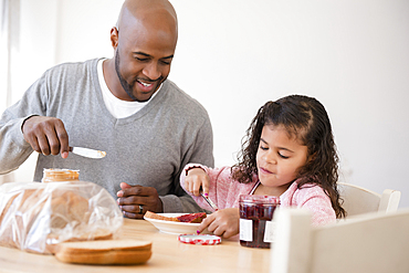 Father and daughter making sandwiches