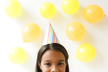 Mixed Race girl wearing party hat