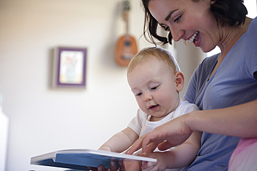 Caucasian mother reading book to baby son