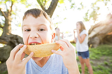 Caucasian boy eating cantaloupe