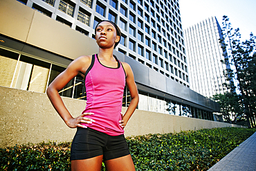 Serious Black woman standing on city sidewalk