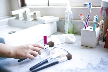 Hand of Hispanic woman holding makeup brush