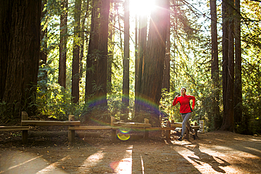 Woman running on sunny forest path