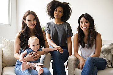 Portrait of smiling friends with baby