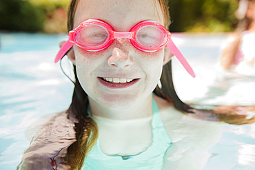 Caucasian girl in swimming pool wearing goggles