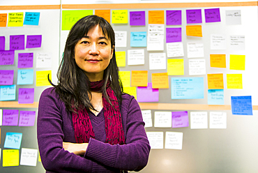 Portrait of Japanese woman near adhesive notes on wall