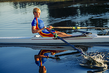 Caucasian man rowing on river