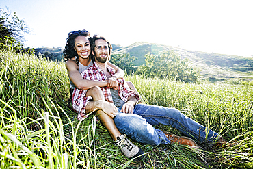 Portrait of smiling couple hugging on hill