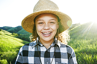 Smiling girl wearing hat on sunny hill