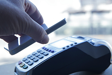 Hispanic man paying with smart phone