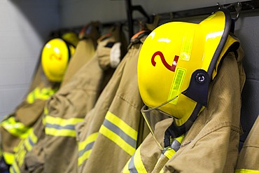 Coats and helmets of fire fighters hanging on hooks