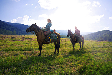 Caucasian girls riding horses in field