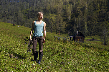 Caucasian girl holding rope on hill