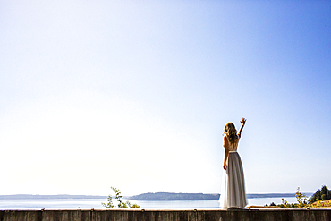 Caucasian bride waving near river