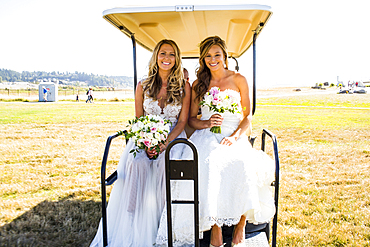 Caucasian brides sitting in golf cart