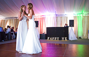 Caucasian brides dancing at wedding