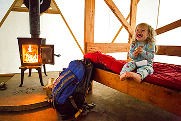 Caucasian girl laughing on bed in yurt