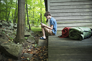 Caucasian boy reading book on wooden patio