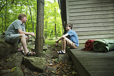 Caucasian father and son talking at cabin