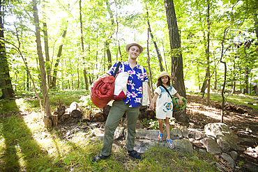 Caucasian father and daughter carrying bags at cabin