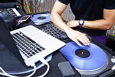 Hispanic dj playing music in backyard