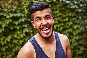 Laughing Middle Eastern man wearing tank-top