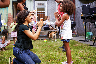 Mixed Race mother and daughter playing clapping game