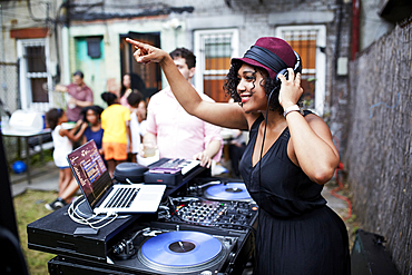 Mixed Race dj playing music at party in backyard