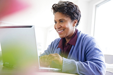 Older black woman using laptop