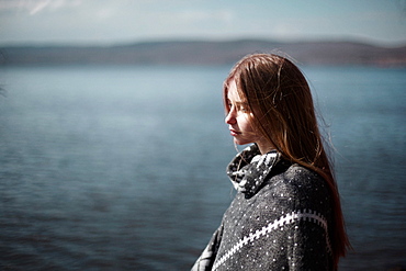 Pensive Caucasian girl at lake