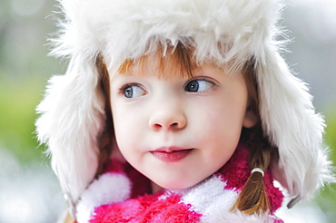 Caucasian girl wearing fuzzy hat outdoors