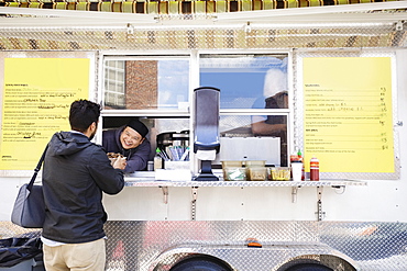 Man buying bowl of food at food truck